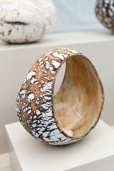 two white and brown vases sitting on top of each other