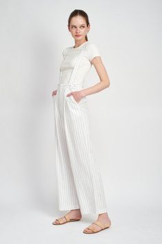 This Hits Different Jumpsuit combines fashion and function. With high waist pinstripe trousers and detachable suspenders, you get a sleek and sophisticated look with the flexibility to style it up or down. Perfect for any occasion. Size Chart Small Medium Large Bust 34 36 38 Waist 26 28 30 High Hip 34 36 38 Low Hip 37 39 41 **in inches** MODEL WEARS SIZE SMALLMODEL'S HEIGHT 5'9 Fabric Contents: 70% RAYON, 30% LINEN Chic Fitted Bottoms With Suspenders, Chic Spring Bottoms With Suspenders, Wide Leg Bottoms With Suspenders For Summer, Summer Wide Leg Bottoms With Suspenders, Chic Fitted Bottoms With Vertical Stripes, Chic Fitted Jumpsuits And Rompers With Vertical Stripes, Fitted Bottoms With Suspenders For Spring, Chic Pinstripe Pants For Summer, Chic Spring Overalls