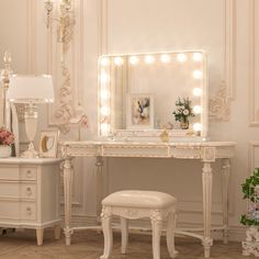 a dressing table with stool, mirror and lights