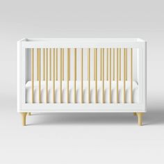 a white crib with wooden slats on the bottom and sides, against a gray background