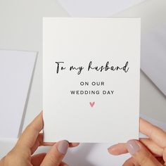 two hands holding up a card with the words to my husband on our wedding day