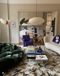 a living room filled with furniture next to a dining room table and chairs on top of a shaggy rug