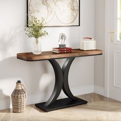 a table with a vase and some books on it next to a door in a room