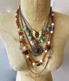 This is an instant, exotic bohemian collection! Let your bohemian soul sing with this layered set of 3 necklaces.  Wear them together or on their own to create different looks. The necklaces are a combination of materials, metals, patterns and finishes for an amazing assortment! Colors of turquoise,  brown, aqua and silver metal, etc.   (1) Designer vintage necklace from the Crown Trifari collection.  This is done out of lucite.  I love the color combination of honey brown, cream, etc.  It has the Crown Trifari hang tag. 24" long, great condition.   (2) Longest necklace is 52".  From the 70s, it is a long silver tone chain that is accented with ball and open cut links.  It has a clasp so you can also double it over.  Great condition. (3) Pretty earth toned enamel butterfly!  She is done in Butterfly Boho, Chunky Stone Necklace, Enamel Butterfly, Boho Turquoise, Bohemian Soul, Vintage Crown, Silver Collection, Crown Trifari, Shades Of Teal