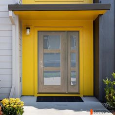 the front door of a yellow building with two glass doors