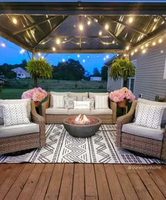 an outdoor living area with couches, chairs and a fire pit