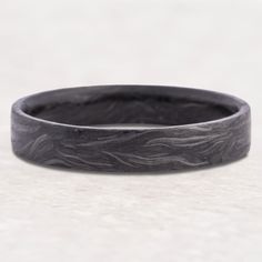 a black wedding band with waves on it