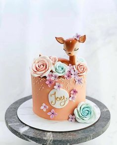 a cake decorated with flowers and a deer on top