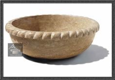 a stone bowl sitting on top of a white table