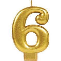 a gold number six candle on a white background