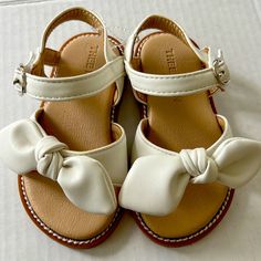 Brand New Never Worn Little Girls, White Sandals, With A Bow And Velcro Strap. Absolutely Adorable. I Believe They Are A 6 Box 1e White Adjustable Non-slip Sandals, White Sandals For Summer Playtime, Adjustable White Sandals For Playtime, White Sandals With Soft Sole For Spring, White Non-slip Flat Sandals, Cute White Sandals For Spring, White Synthetic Sandals With Soft Sole, White Flat Sandals With Soft Sole, Adjustable Non-slip White Sandals