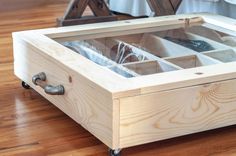 an open wooden box with glass inside on the floor