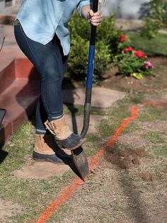 a woman is using a shovel to dig the ground