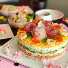 there is a cake that has shrimp on it and other food in bowls behind it