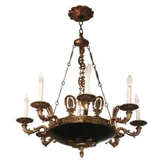 an antique chandelier with five candles hanging from it