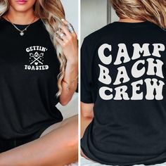 a woman wearing a black shirt that says camp back crew on the front and bottom