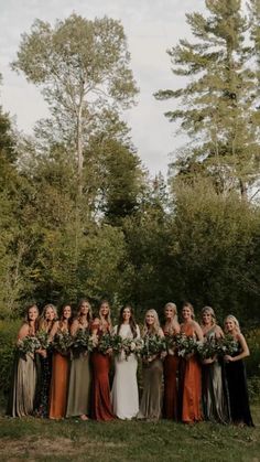 a group of women standing next to each other in front of trees