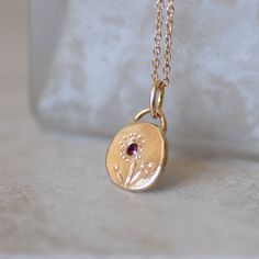 Ruby and gold wildflower necklace. I melted and hammered 1.4 grams of 14k yellow Gold into an organically shaped disc. I set a 2mm grade AAA natural red ruby into it, and used chasing tools to hand draw a wildflower motif on the pendant. Hangs from a delicate 1mm cable chain with a spring clasp. Pebble - about 9mm x 11mm's, and roughly 2mm's thick Because each pendant is made by hand, no two will be exactly the same. That being said, I am a perfectionist when it comes to my work and will not be Wildflower Necklace, Ruby Flower, Flower Necklace Gold, Pebble Pendant, Necklace Ruby, Gold Coin Necklace, Hand Draw, Ruby Necklace, For Her Gifts