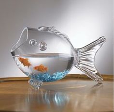 a glass fish bowl sitting on top of a wooden table