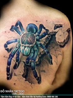 the back of a man's shoulder with a spider on it and some flowers