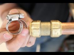 a person holding a metal pipe with a ring on it's end and an object in the background