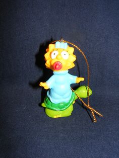 the simpsons character is sitting on top of a turtle ornament with a rope