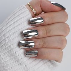 a woman's hand with silver nail polish on it