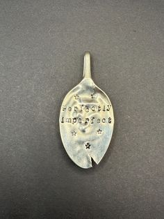 a silver pendant with words on it that says, wonderful imperfecter and stardust