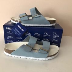 Birkenstock's Signature Arizona Sandals, Now Reimagined In Blue Grained Leather, Were Introduced In 1973 And Have Since Risen To Cult Status. They're Made In The Label's Native Germany. Brand New In Box Sizes: 38eu = 7/7.5us 39eu = 8/8.5us 40eu = 9/9.5us Color: Sky Upper: Natural Nubuk Leather Footbed: Natural Cork Logo-Engraved Buckles Adjustable Straps Eva Rubber Sole Made In Germany. Casual Blue Slip-on Footbed Sandals, Casual Blue Leather Slides, Blue Leather Footbed Slip-on Slides, Blue Synthetic Sandals With Leather Footbed, Blue Flat Sandals With Cushioned Footbed, Blue Leather Footbed Sandals For Spring, Blue Leather Sandals With Textured Footbed, Blue Flat Heel Sandals With Cushioned Footbed, Comfortable Blue Open Toe Footbed Sandals