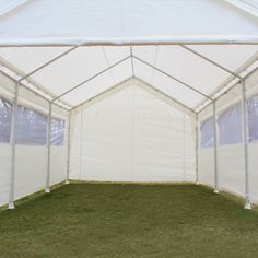 the inside of a large white tent with grass and trees in the backgroud