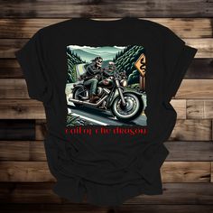 "Tail of the Dragon Unisex Tshirt, Blue Ridge Mountain Life, Motorcycle Route in the Blue Ridge, Biker Shirt, Biking the Blue Ridge Mountains Embrace the thrill of the  Blue Ridge Mountains Life with our unique Tail of the Dragon T-shirt! Perfect for biking enthusiasts,  and lovers of quirky motorcycle apparel.  This shirt features a skeleton rider sitting atop his bike as he rides the \"Tail of the Dragon,\" one of the east coasts most famous rural biking routes. 👕 Premium Quality Fabric: Craf Casual Screen Print T-shirt For Biker Events, Casual Crew Neck Tops For Motorcycling, Motorcycling Graphic Tee With Short Sleeves, Graphic Tee For Motorcycling With Short Sleeves, Cotton Biker Tops With Letter Print, Casual T-shirt With Front Print For Biker Events, Cotton Biker Top For Biker Events, Motorcycling Graphic Tee Crew Neck, Motorcycling Graphic Tee With Crew Neck