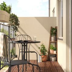 a balcony with chairs, table and potted plants