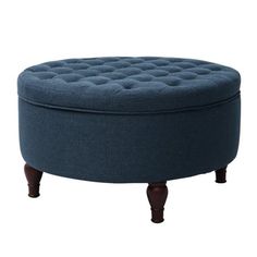 a round ottoman sitting on top of a wooden table