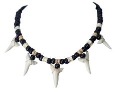 a necklace with black beads and white spikes on the front, along with two other pieces of jewelry