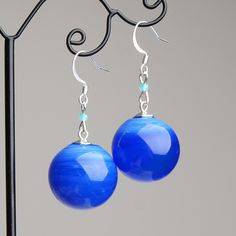 "These Blue ball dangle earrings are good for everyday outfits and for special occasions. They can be a great gift for her! Dimensions: total length is 2\" inch (5cm), ball diameter 0.9\" inch (2.2cm). Materials: artist lampwork glass beads, silver plated hooks. Colors used: blue. For your information: ✦ Get free shipping when you buy any two or more items! ✦ All jewelry is shipped with some kind of gift wrapping, box or bag depending on size. ✦ Your order will be packed very carefully and will Trendy Blue Round Bead Earrings, Trendy Blue Sterling Silver Earrings, Trendy Light Blue Dangle Earrings, Blue Sterling Silver Earrings With French Hook, Sterling Silver Blue French Hook Earrings, Trendy Light Blue Drop Earrings, Blue Dangle Earrings With French Hook, Blue Hypoallergenic Round Bead Earrings, Blue Hypoallergenic Earrings With Round Beads