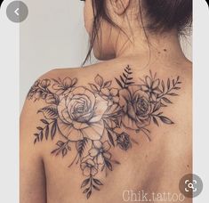 a woman's back tattoo with flowers and leaves