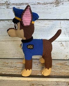 a crocheted dog with a blue shirt and hat on it's head