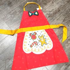 a child's apron with an image of mickey mouse on it and a bow tie