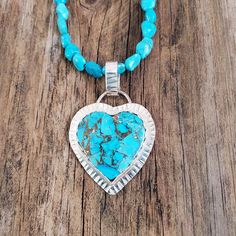 BLUE COPPER MOHAVE TURQUOISE HEART NECKLACE This striking blue copper Mohave turquoise heart necklace has been bezel set in sterling silver with a scallop edging. For added interest the sterling face plate has been stamped for glint and contrast.  The pendant is hanging on beautiful blue turquoise nugget beads that come from Pinto Valley, AZ that pair nicely with the color of the heart. The necklace length is 19 inches with some adjustment to shorten with the sterling hook closure. The pendant's Turquoise Heart Charm Pendant Necklace, Turquoise Pendant Necklace With Heart Charm, Bohemian Blue Heart Pendant Jewelry, Blue Bohemian Heart Pendant Jewelry, Turquoise Heart Pendant Jewelry With Natural Stones, Spiritual Blue Jewelry With Heart Charm, Turquoise Heart Charm Jewelry, Turquoise Heart Charm Pendant Jewelry, Bohemian Turquoise Heart Pendant Jewelry