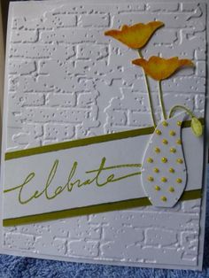 a white card with yellow flowers and the word celebrate written in cursive writing