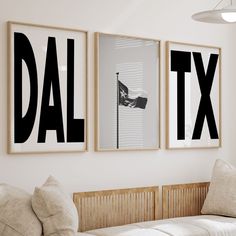 three black and white posters hanging on the wall above a couch in a living room