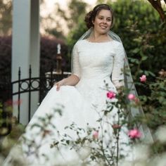 a woman in a wedding dress standing outside