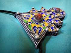 Ancient Berber talisman (herz) in sterling silver, enamelled in blue, green and yellow color. and decorated with a real coral cabochon. Height: 7 cm. Width: 5.5 cm. Leather: 54 cm. ++Material: sterling silver 925, real coral cabochon. ++Weight: 31.8 grams. ++ Origin: Morocco 1970s. Free worldwide shipping by DHL. I am always open to offers for one of my items, so please contact me if you would like to make an offer. Don't hesitate to contact me for any questions. All items advertised for sale ar Traditional Handmade Heart Jewelry, Traditional Heart Shaped Jewelry Gift, Traditional Handmade Heart-shaped Jewelry, Traditional Heart-shaped Jewelry Gift, Unique Heart-shaped Festival Jewelry, Antique Multicolor Jewelry For Gift, Antique Multicolor Jewelry Gift, Traditional Handmade Heart Necklaces, Vintage Locket Jewelry For Festivals