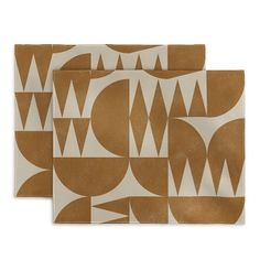 two brown and white placemats sitting on top of each other