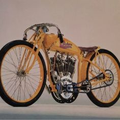 an old fashioned yellow motorcycle parked on top of a white floor