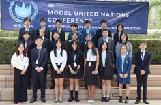 a group of young people standing next to each other in front of a blue sign