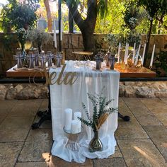 a table set up with candles and vases