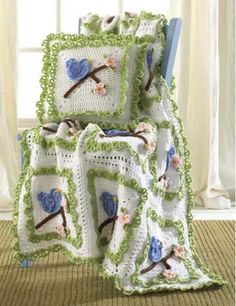 a crocheted blanket with two blue birds on it