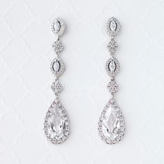 two pairs of diamond earrings on a white background