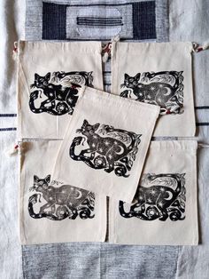 four black and white cats on linen bags